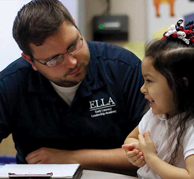 Teacher working with student at desk